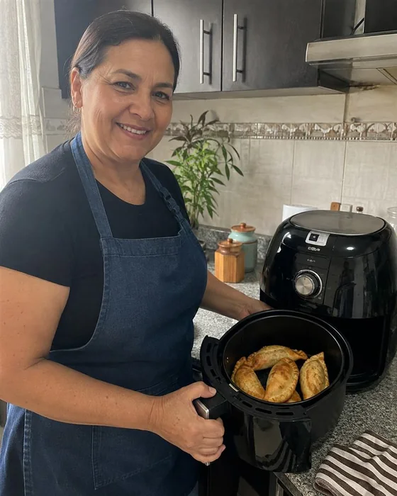 Ana sacando una preparación de su Air Fryer en su cocina